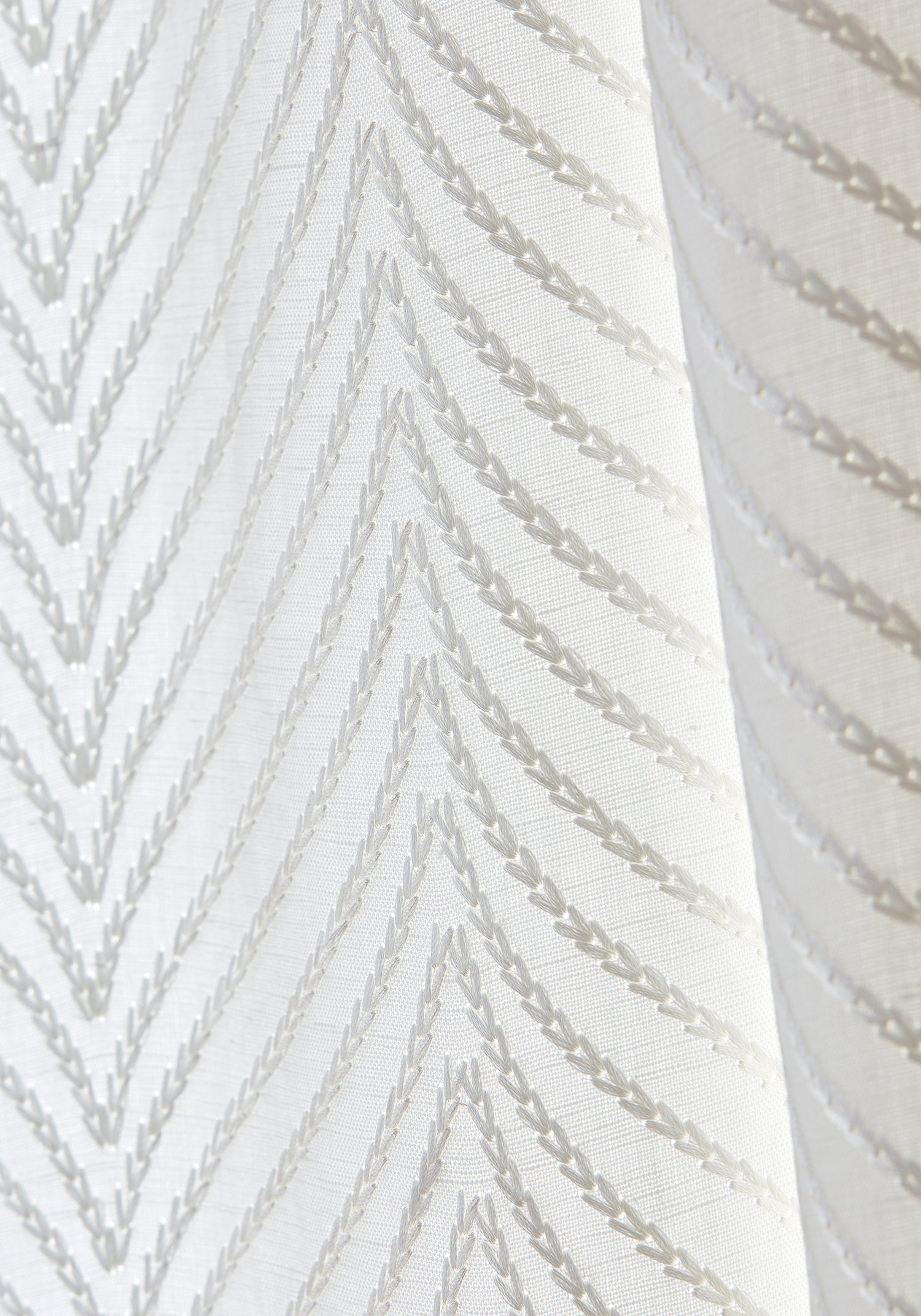 Detailed view of Drapery in Clayton Herringbone woven fabric in ivory color variant by Thibaut in the Dynasty collection - pattern number W775444