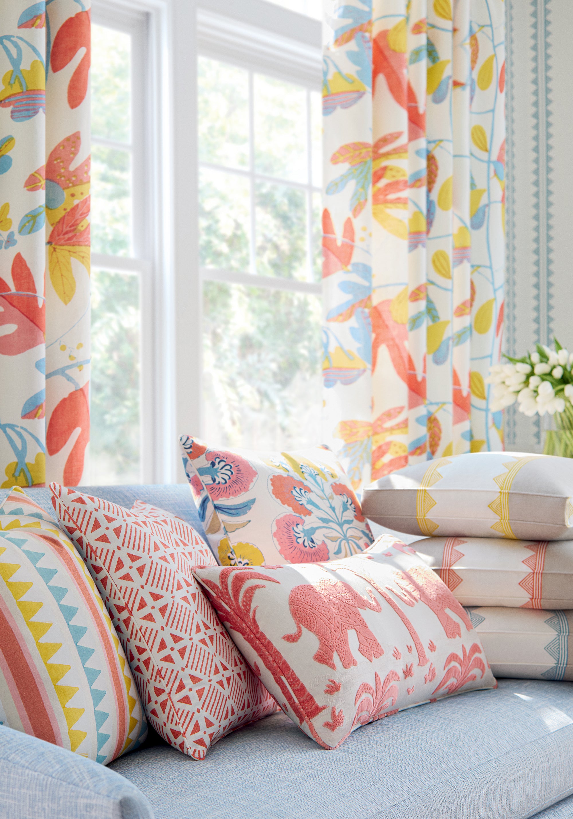 Designer living room with curtains made from Matisse Leaf fabric in coral and yellow color - pattern number F916206 - by Thibaut fabric