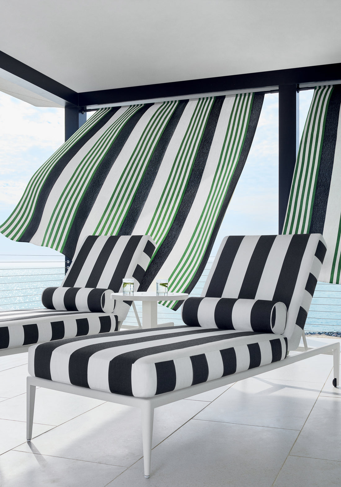 Outdoor chaise lounge chairs upholstered in Cabana Stripe fabric in onyx color - pattern number W81638 - by Thibaut fabrics