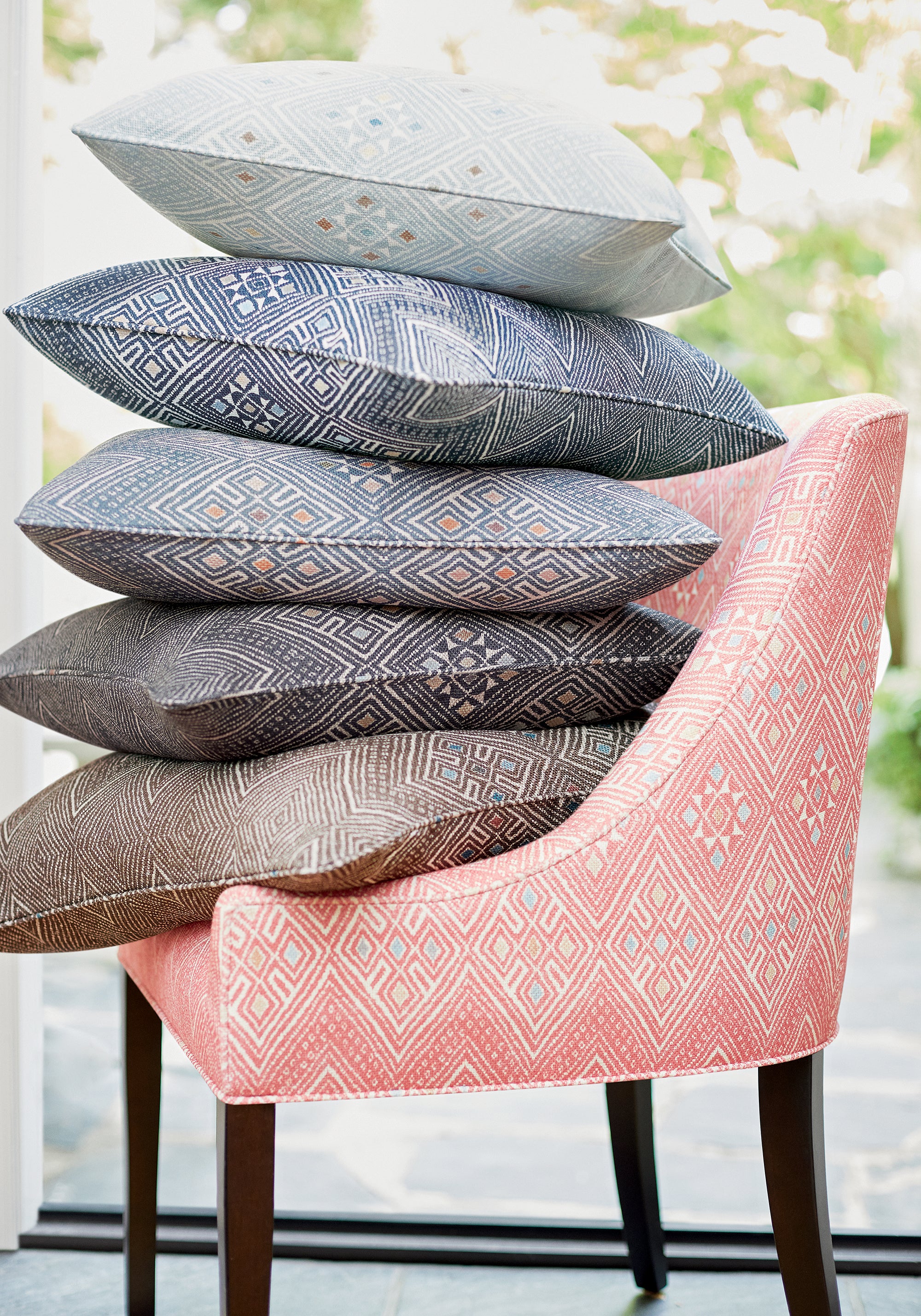 Morgan Dining Chair and collection of High Plains printed fabric pillows featuring coral color fabric - pattern number F913230 - by Thibaut in the Mesa collection