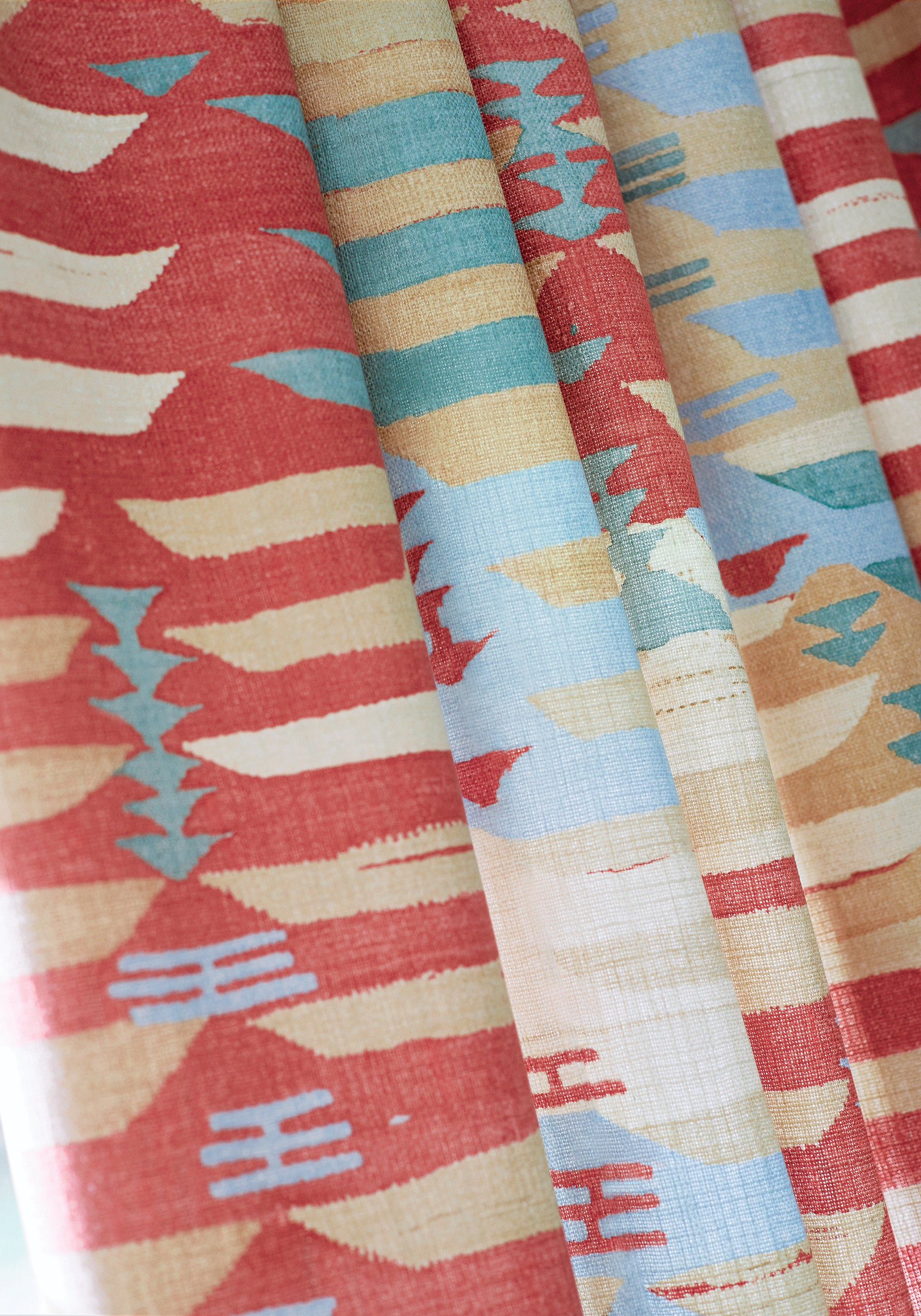 Detailed view of draperies in Rio Grande printed fabric in coral color variant by Thibaut in the Mesa collection - pattern number F913212