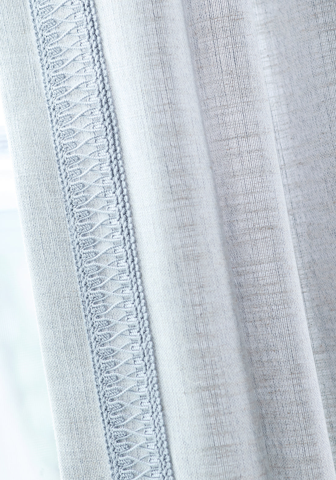 Detail of Terra Linen wide woven fabric drapes in sky color and mineral-colored fabric tape of the Palisades collection by Thibaut - pattern number FWW7683