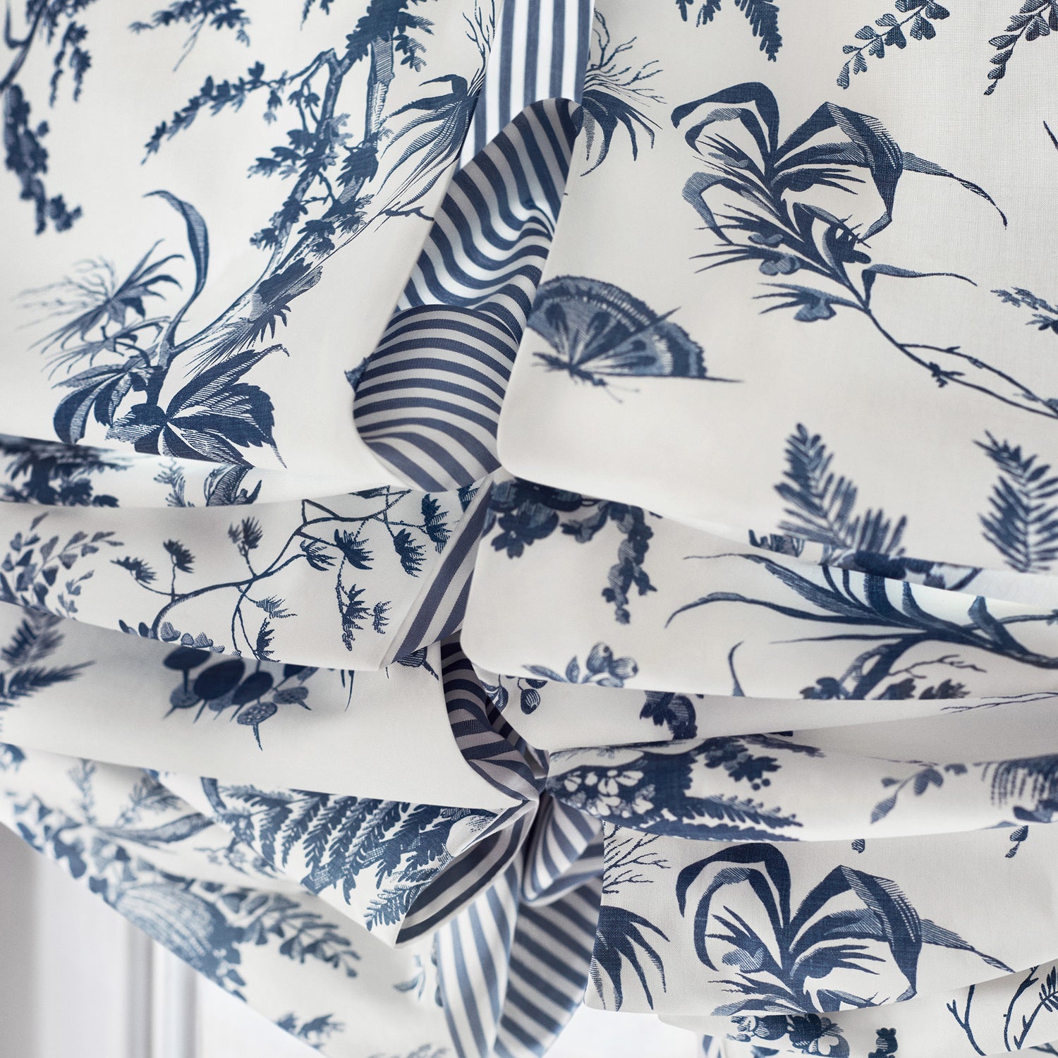 Detailed view of Roman shades in Newlands Toile printed fabric in blue color variant by Anna French in the Bristol collection - pattern number AF57837