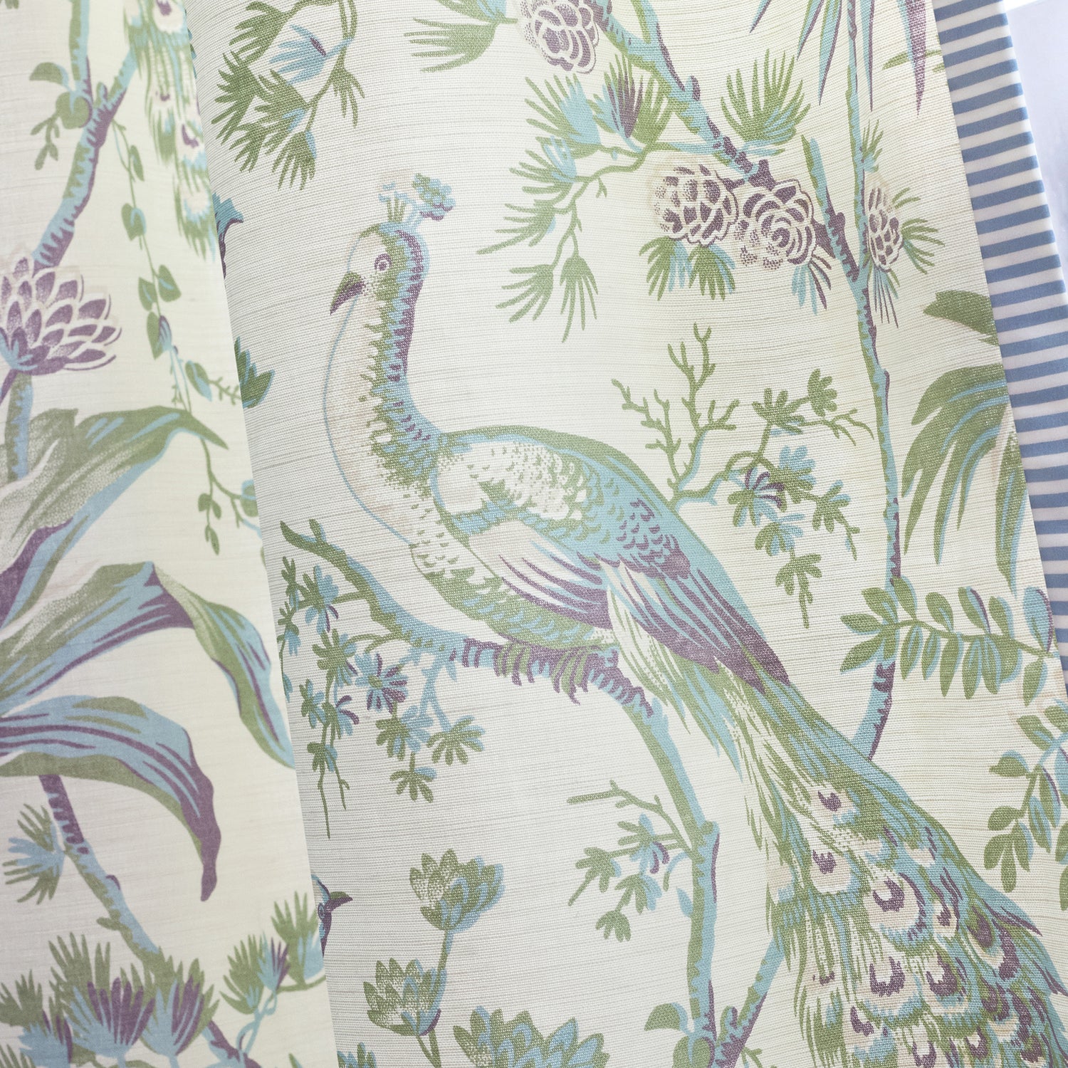 Detailed view of draperies in Peacock toile printed fabric in green and plum color variant by Anna French in the Bristol collection - pattern number AF57829