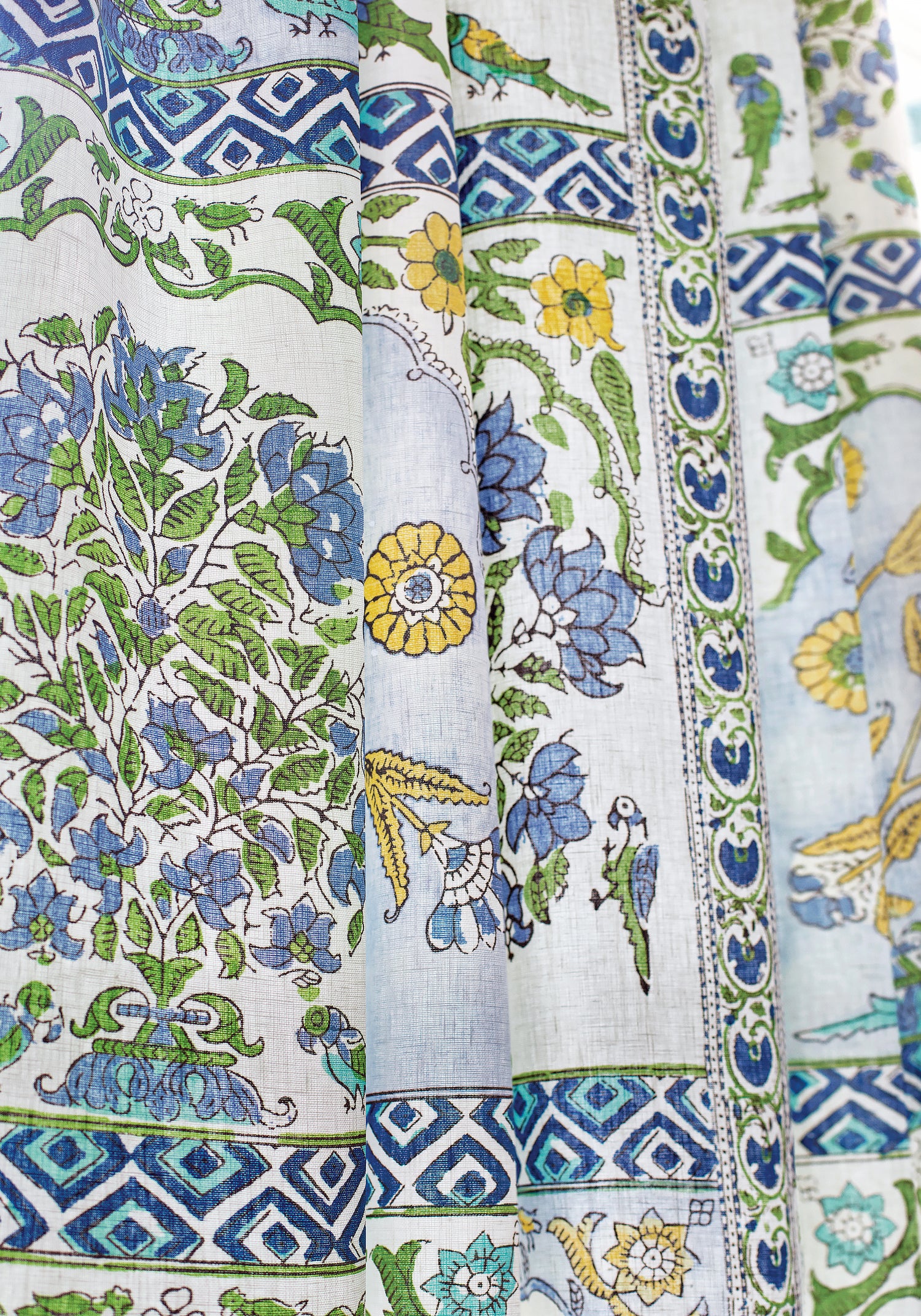 Closeup of drapery curtains made with Thibaut Indian Panel printed fabric in Blue and Yellow