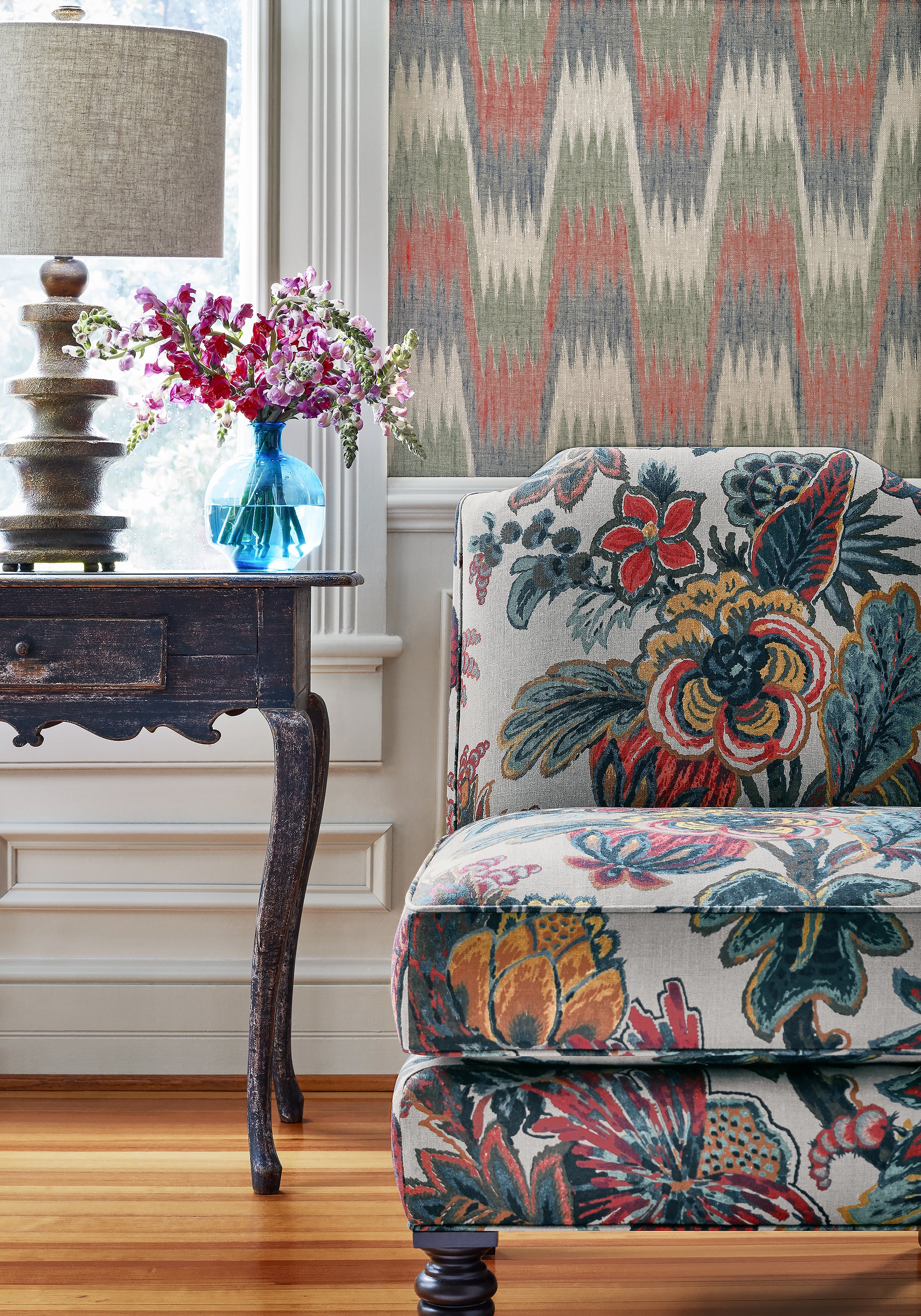 Detailed view of Charlotte chair in Floral Gala printed fabric in jewel color variant by Thibaut in the Colony collection - pattern number F910216