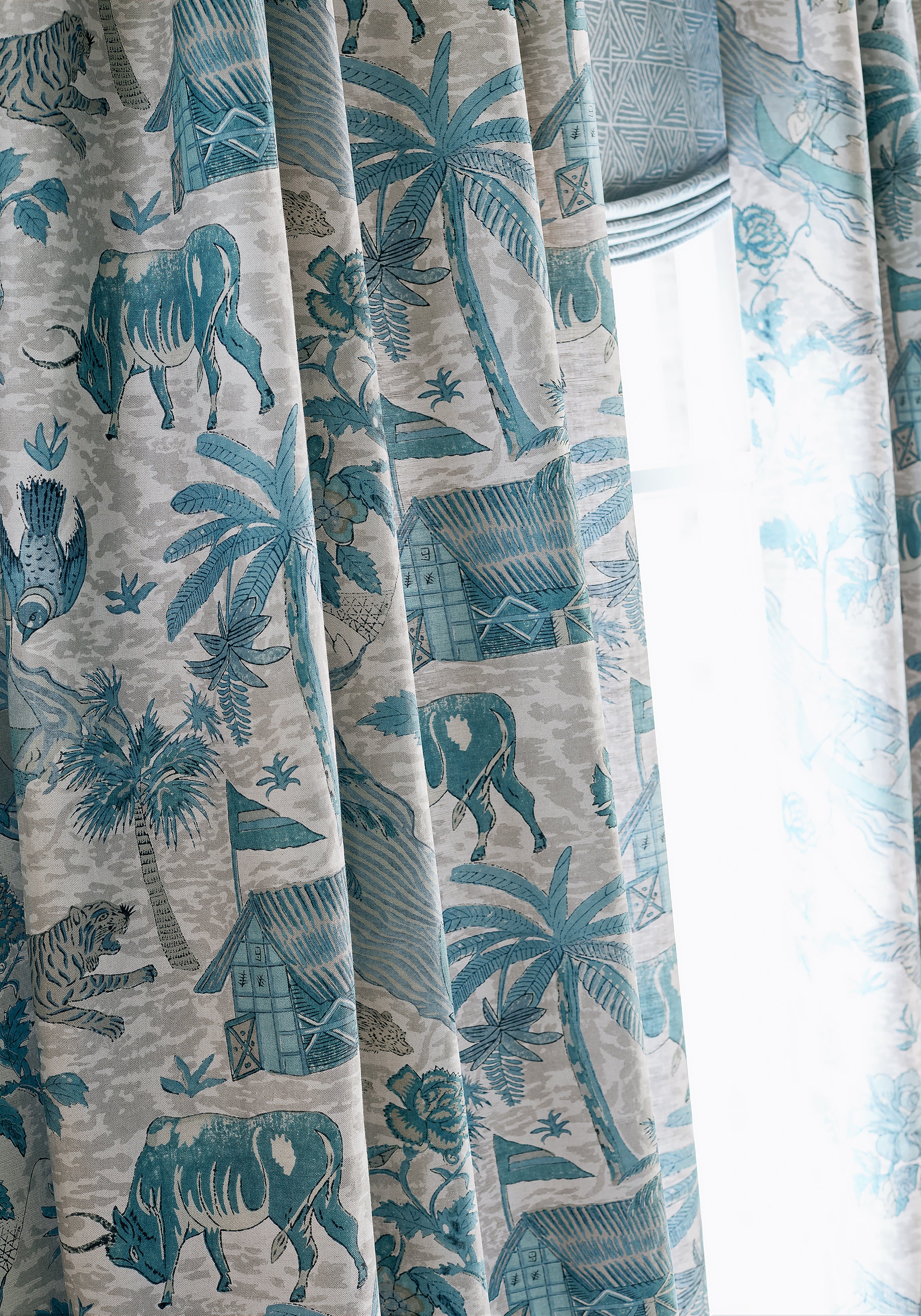 Detailed view of drapes in Tiger Reserve printed fabric in slate blue color variant by Thibaut in the Colony collection - pattern number F910231
