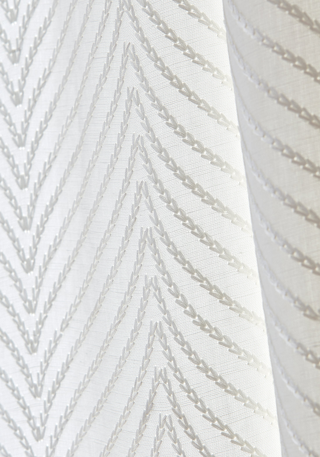 Detailed view of Drapery in Clayton Herringbone woven fabric in ivory color variant by Thibaut in the Dynasty collection - pattern number W775444