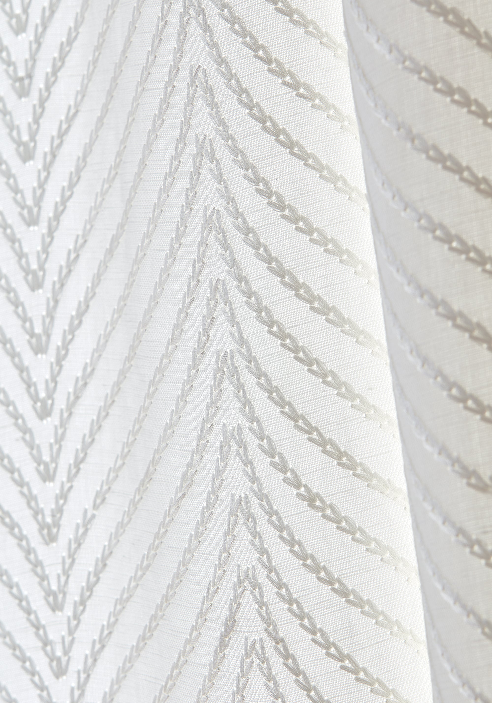 Detailed view of Drapery in Clayton Herringbone woven fabric in ivory color variant by Thibaut in the Dynasty collection - pattern number W775444