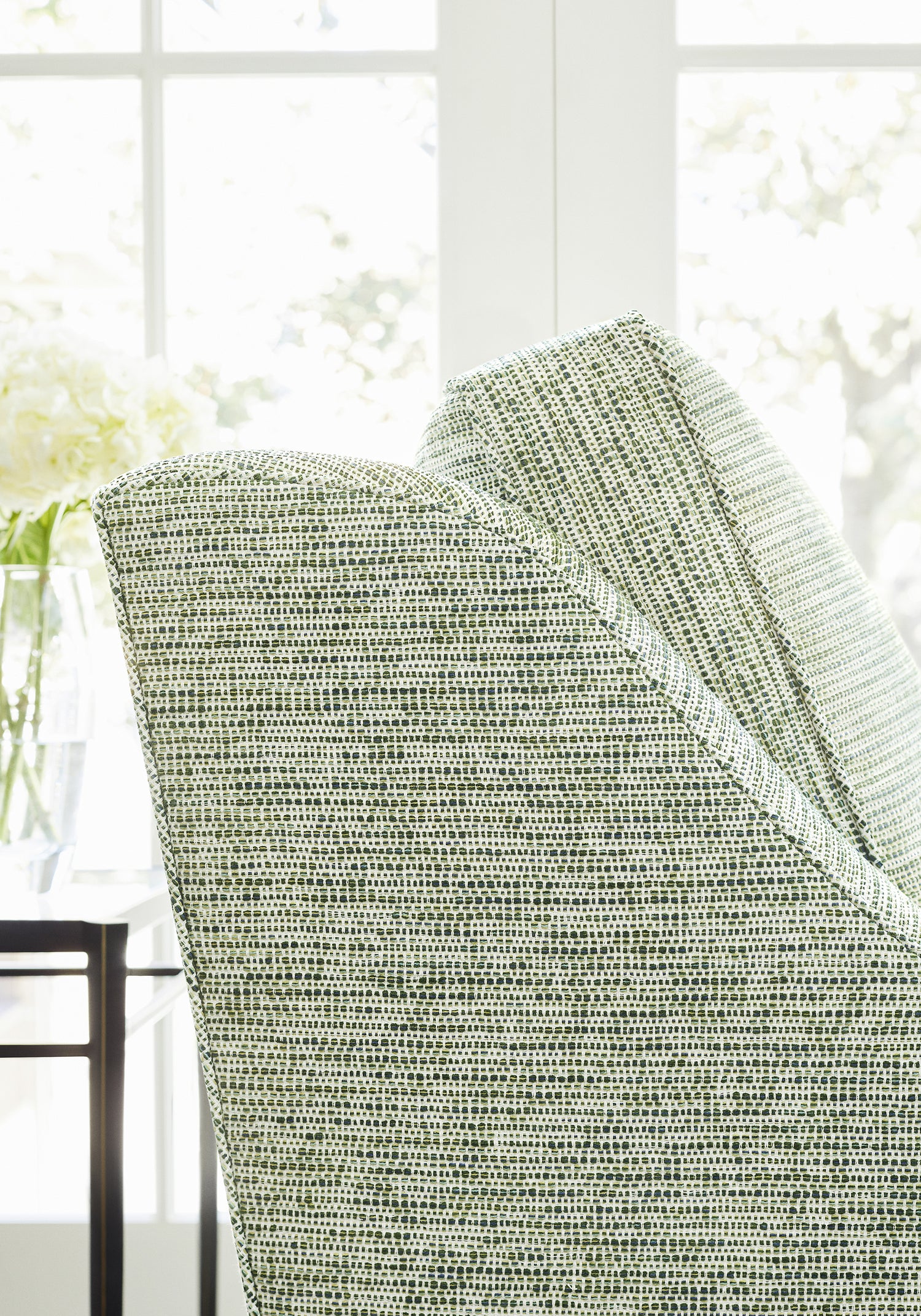 Closeup of chair upholstered in Borealis fabric in emerald color - pattern number W75231 - by Thibaut in the Elements collection