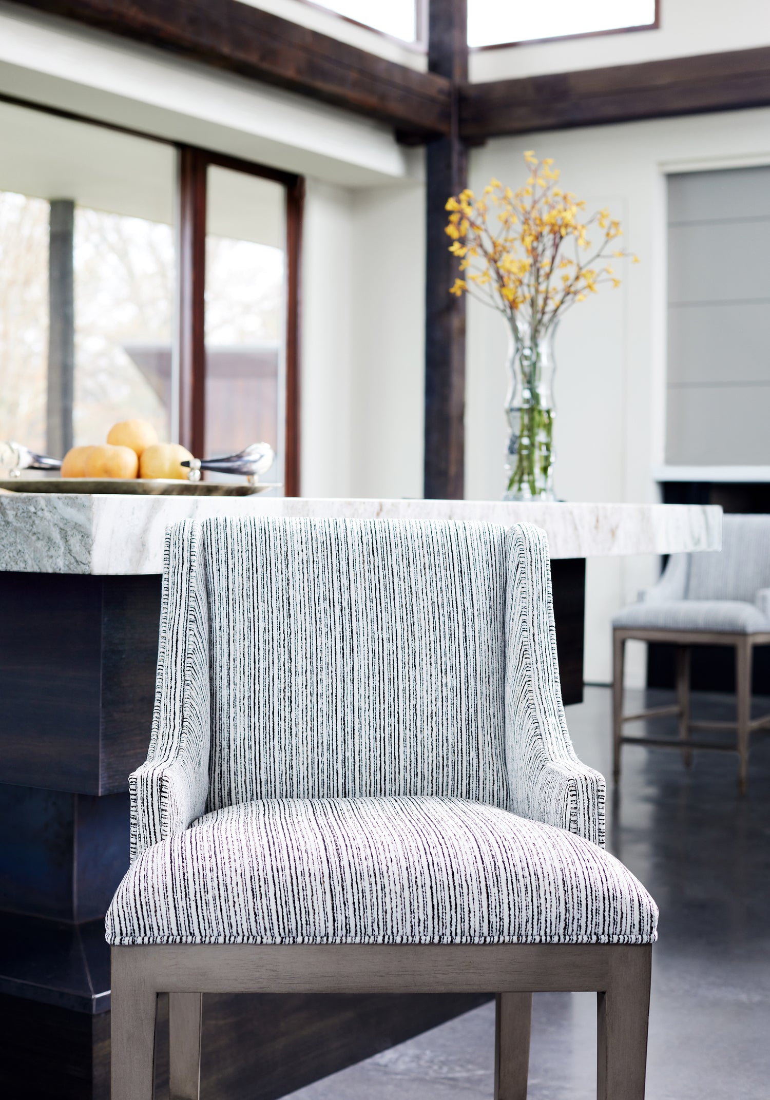 Close view of counter stool featuring Zia Stripe fabric in ebony color - pattern number W8807 - by Thibaut in the Haven collection