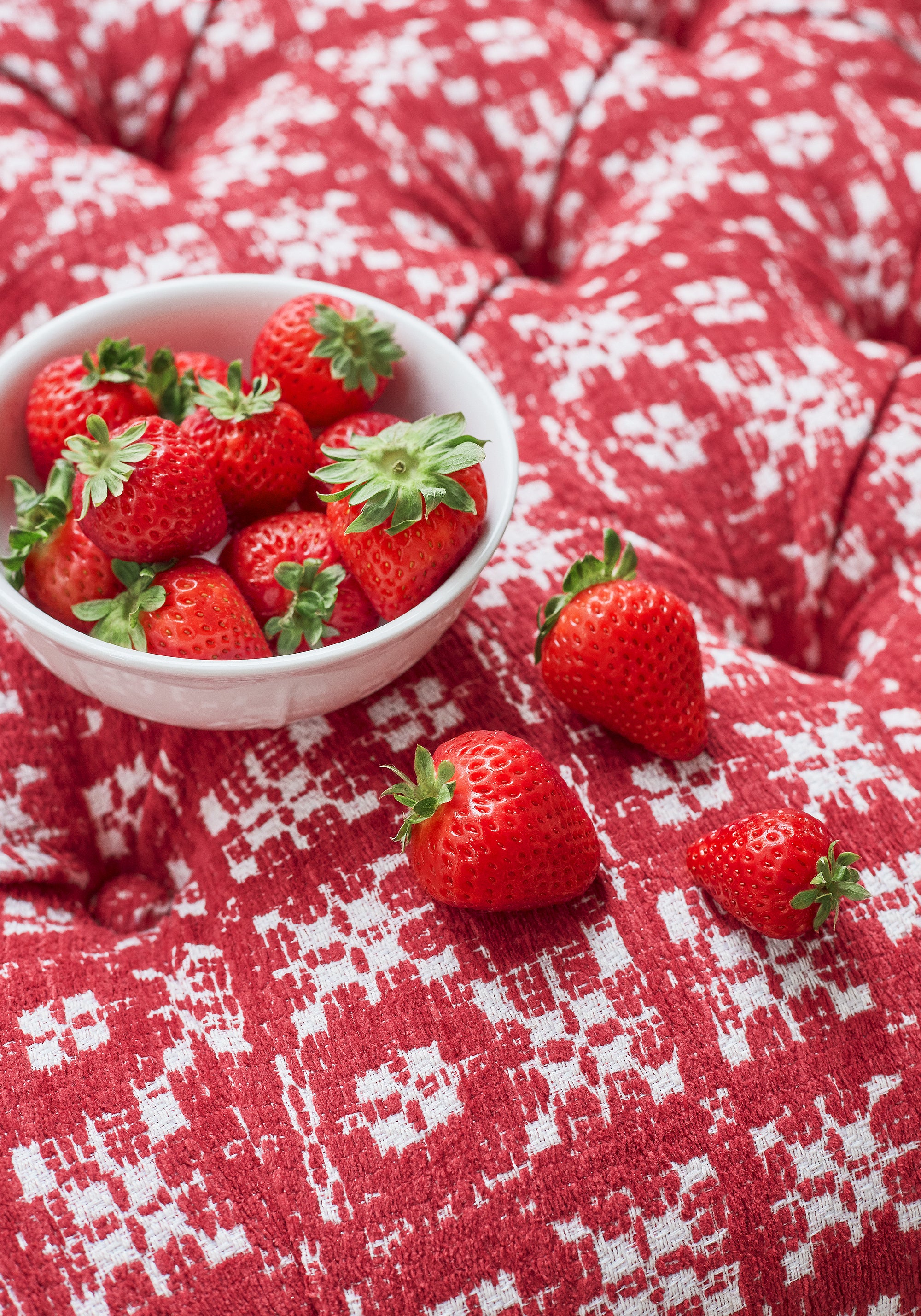 Detailed view of strawberries on top of Brimfield woven fabric in cranberry color variant by Thibaut in the Landmark collection - pattern number W73497