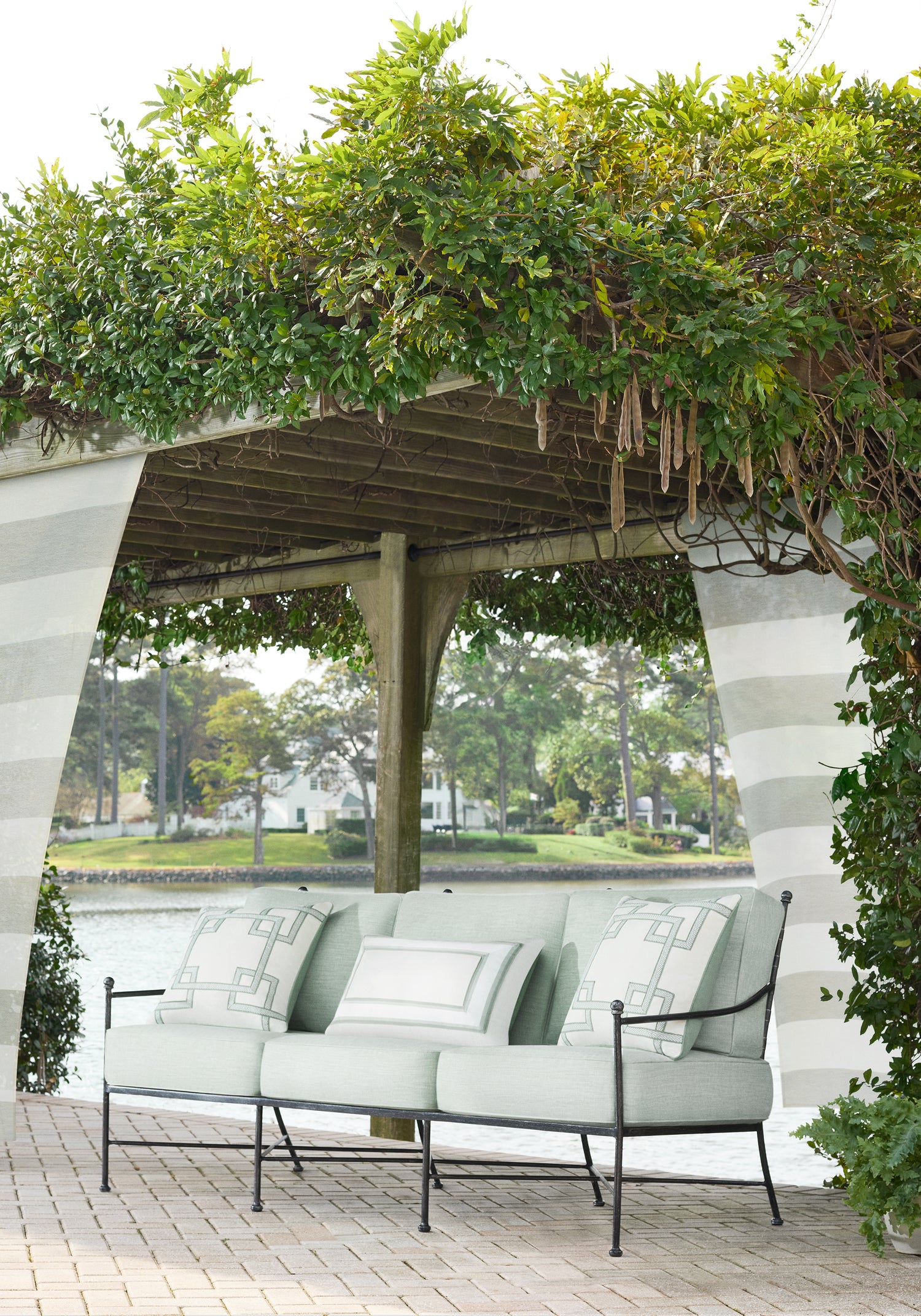 Outdoor living space with drapery panels in Meridian woven fabric in Dove color by Thibaut fabrics