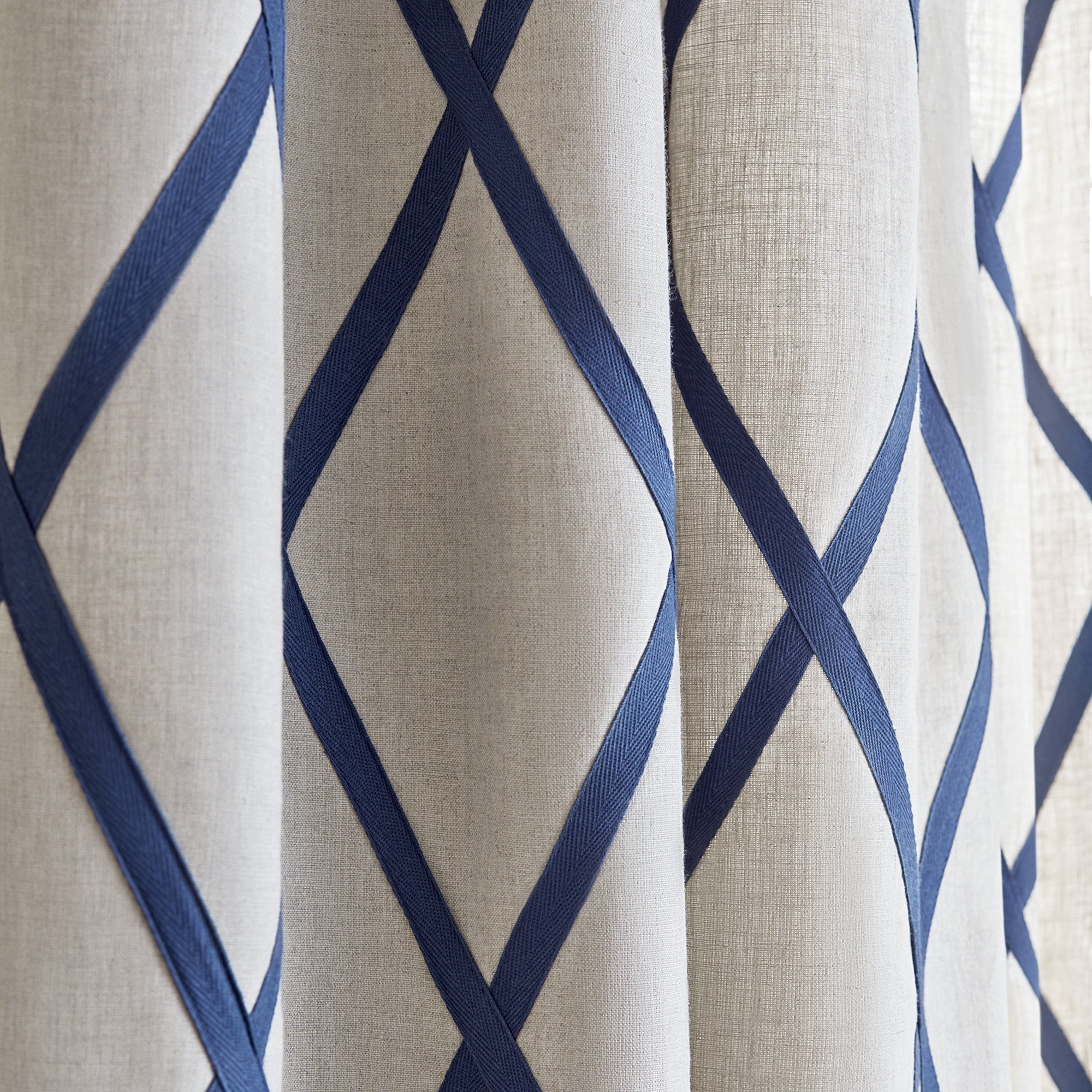 Detail view of draperies made with Tarascon Trellis Applique fabric in navy on natural color - pattern number AW78713 - by Anna French