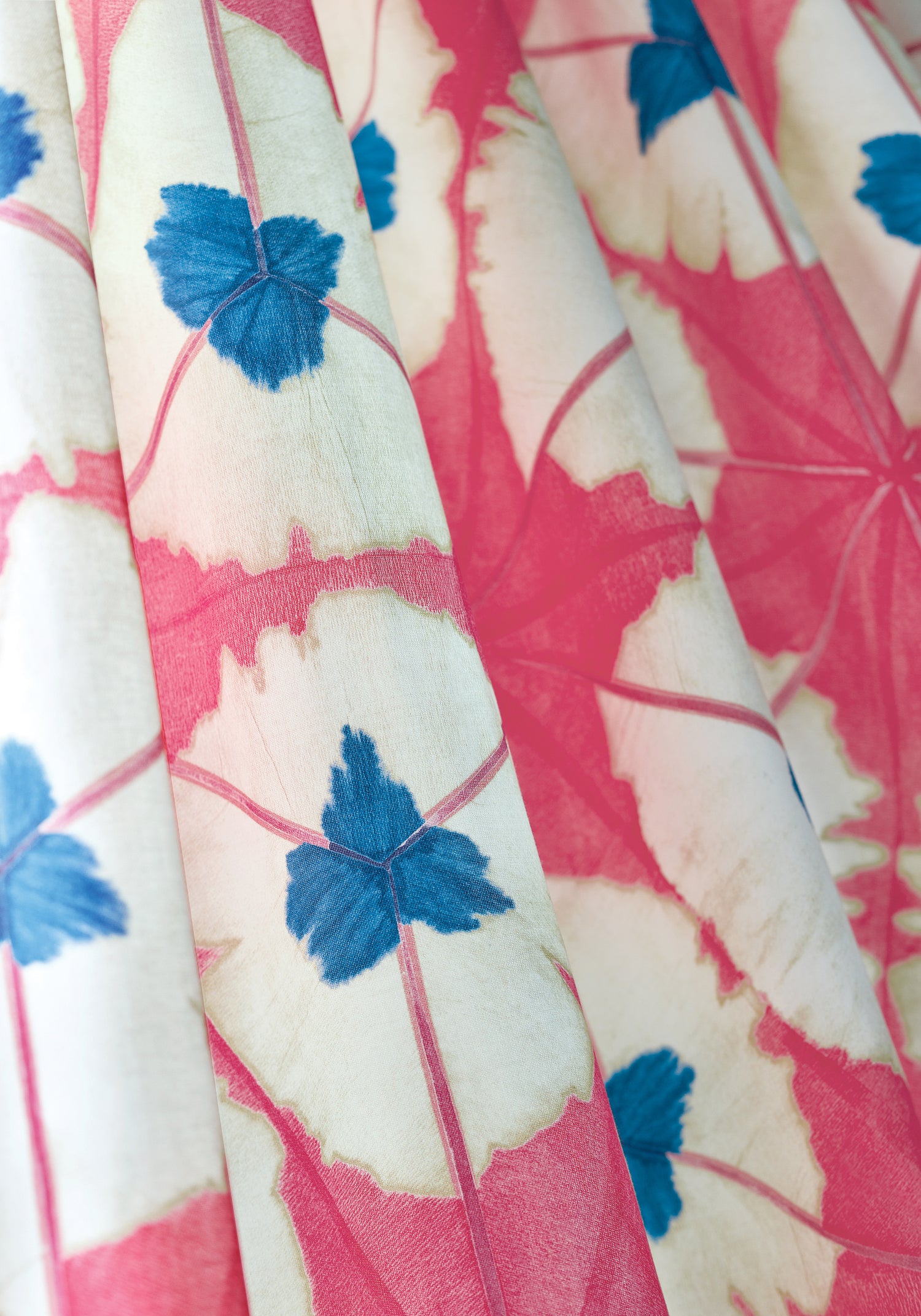 Detail of Sunburst printed fabric in pink and blue color of the Summer House collection by Thibaut - pattern number F913087