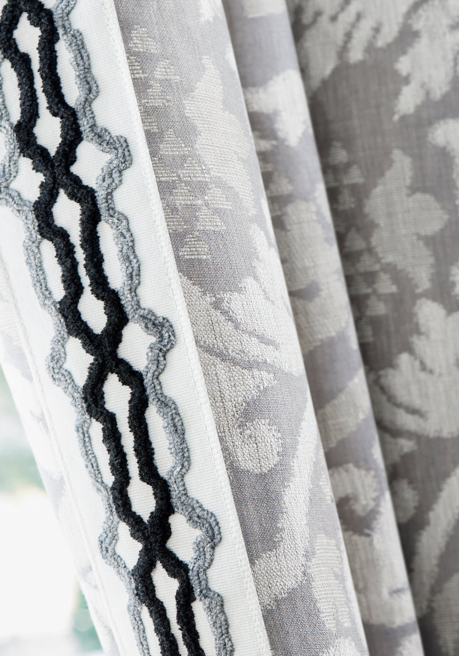 Detail of draperies in Earl Damask woven fabric in charcoal color with flannel and onyx trim - pattern number W710840 - by Thibaut in the Heritage collection
