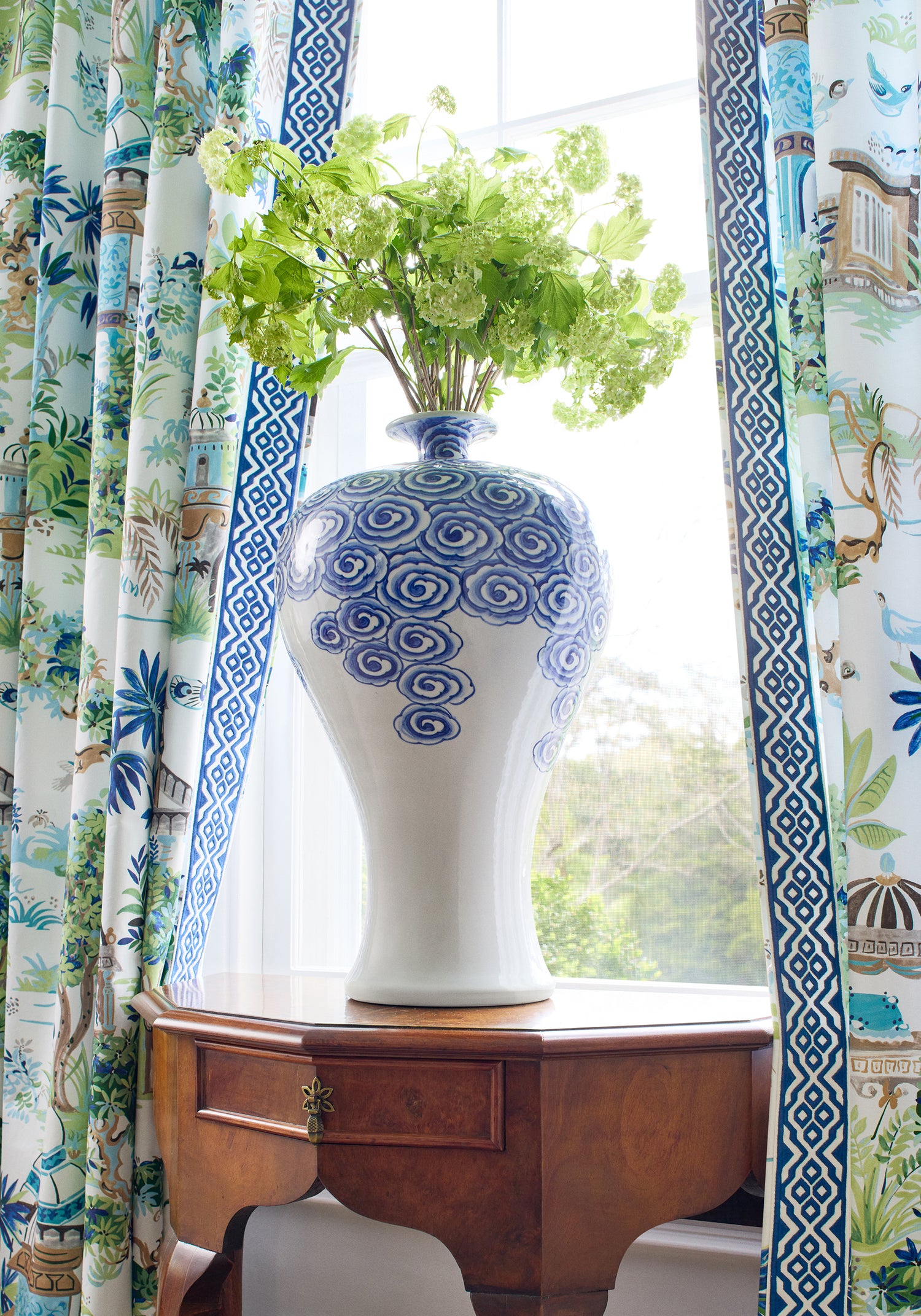 Detailed view of draperies in Mystic Garden printed fabric in blue and green color variant by Thibaut in the Eden collection - pattern number F920820