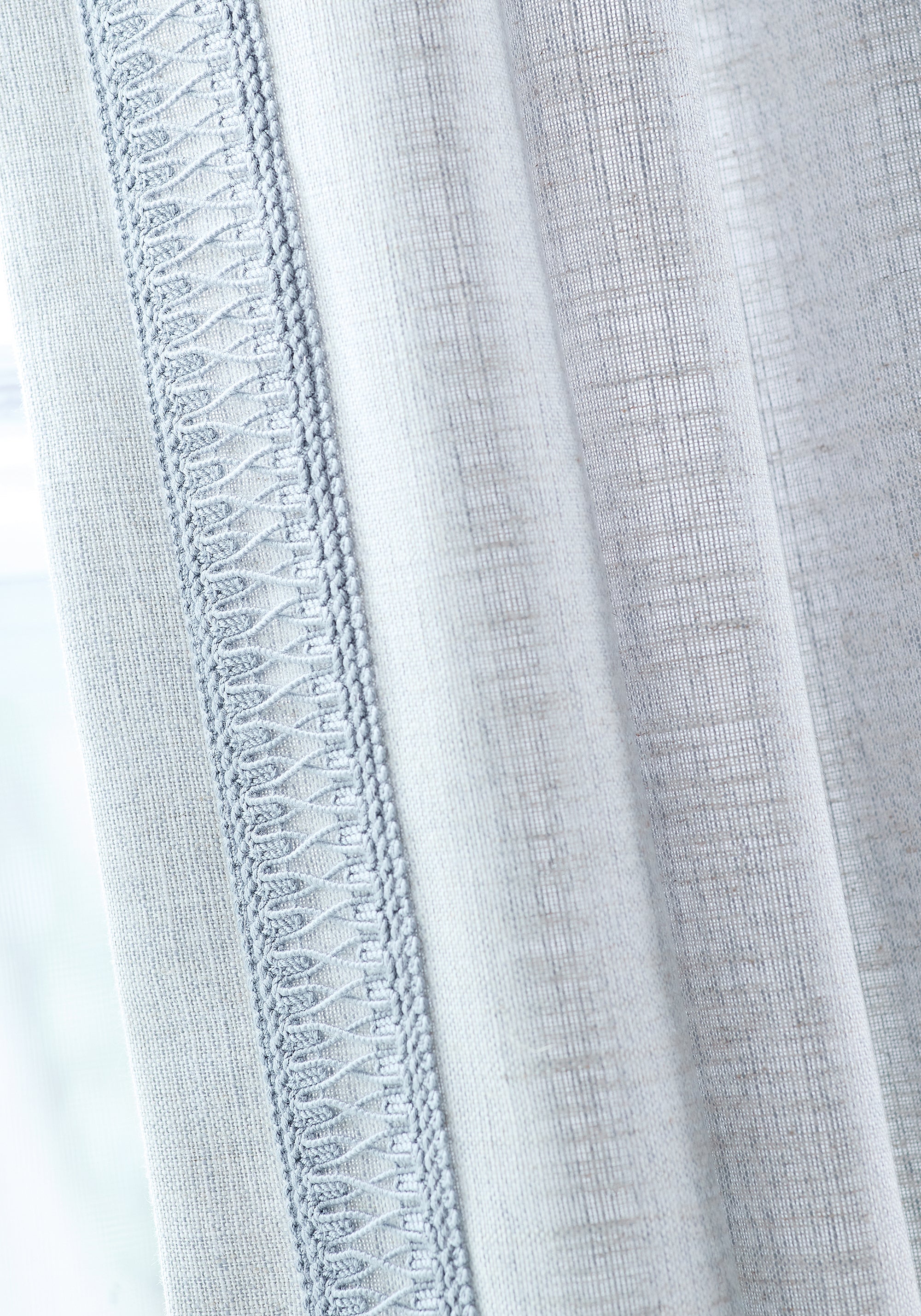 Detail of Terra Linen wide woven fabric drapes in sky color and mineral-colored fabric tape of the Palisades collection by Thibaut - pattern number FWW7683